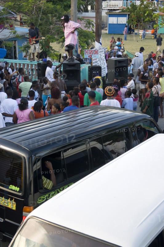 WEST INDIES, St Vincent & The Grenadines, Union Island, Singer and guitarist with sound system by busy street at Easterval Easter Carnival in Clifton