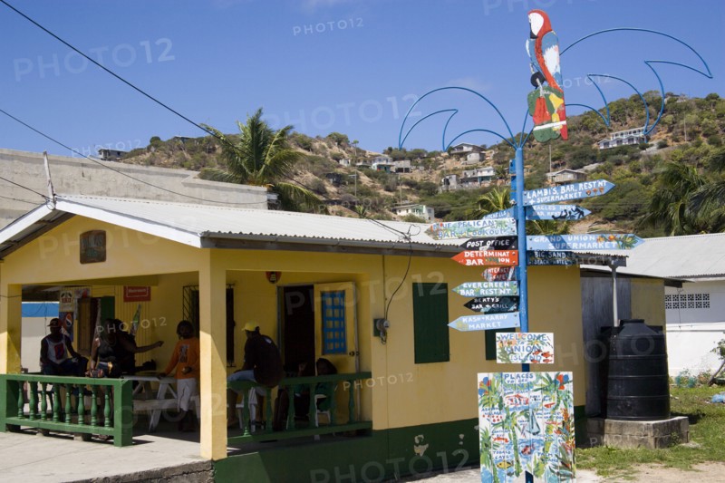 WEST INDIES, St Vincent & The Grenadines, Union Island, Signpost beside a rum shop in Clifton