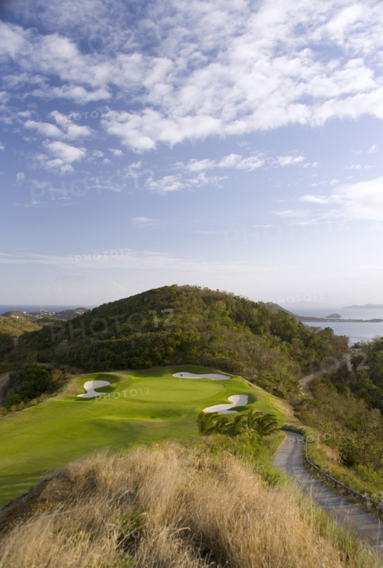 WEST INDIES, St Vincent & The Grenadines, Canouan, Raffles Resort showing the 12th green on the Trump International Golf course with the southern Grenadine islands in the distance