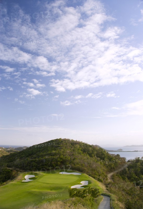 WEST INDIES, St Vincent & The Grenadines, Canouan, Raffles Resort showing the 12th green on the Trump International Golf course with the southern Grenadine islands in the distance