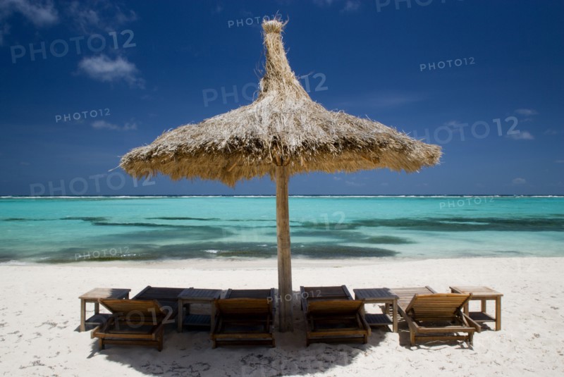 WEST INDIES, St Vincent & The Grenadines, Canouan, Palapa thatched shelter and sunbeds on Godahl Beach at Raffles Resort