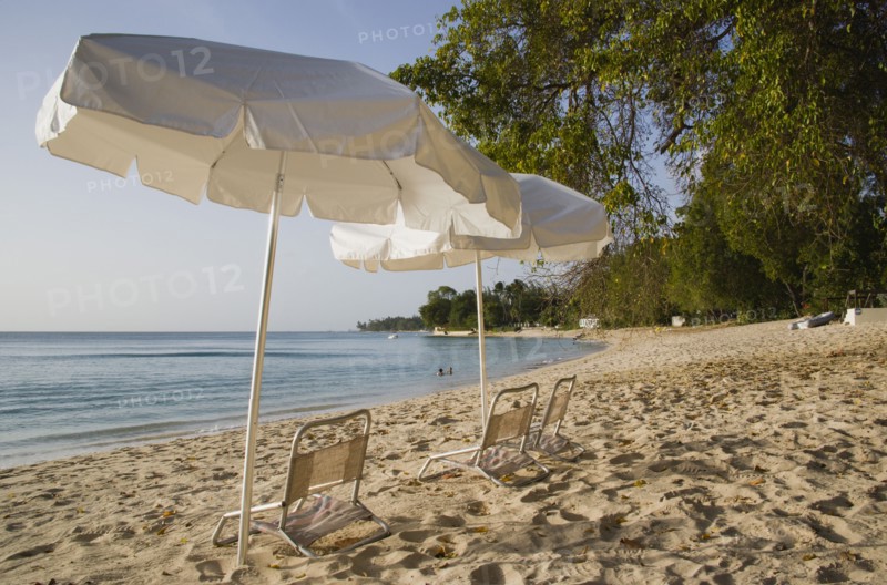 WEST INDIES, Barbados, St Peter, Sunshade umbrellas on Gibbes Bay beach in late afternoon