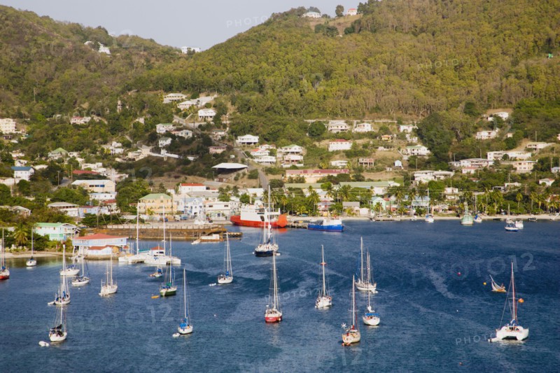 WEST INDIES, St Vincent & The Grenadines, Bequia, Port Elizabeth with yachts moored in Admiralty Bay with the ferry port and hillside housing beyond