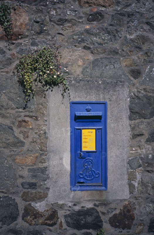 UNITED KINGDOM, Channel Islands, Guernsey, Traditional blue post box on wall.