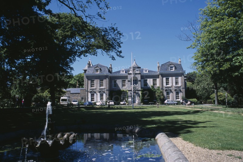 UNITED KINGDOM, Channel Islands, Guernsey, St Martins. Saumarez House. View of front entrance from green lawn over pond.