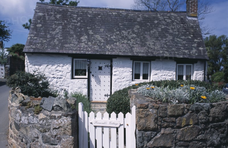UNITED KINGDOM, Channel Islands, Guernsey, St Saviours. Small white cottage on corner of road junction.