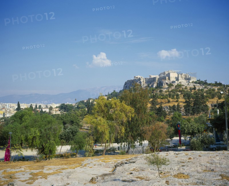 GREECE, Central, Athens, A road with trees either side in the foreground with the Acropolis up the hill.
