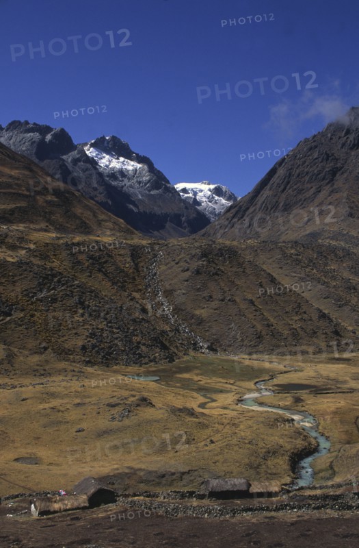 BOLIVIA, Cordillera Norte , Settlement with mountains behind with snow on the peaks.