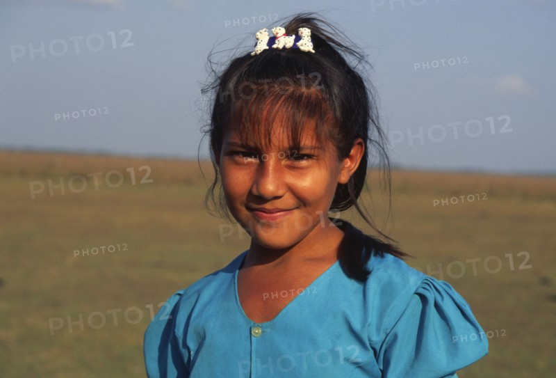COLOMBIA, Casanare, A young Llanera girl wearing a blue top and a hair clip with dogs on.