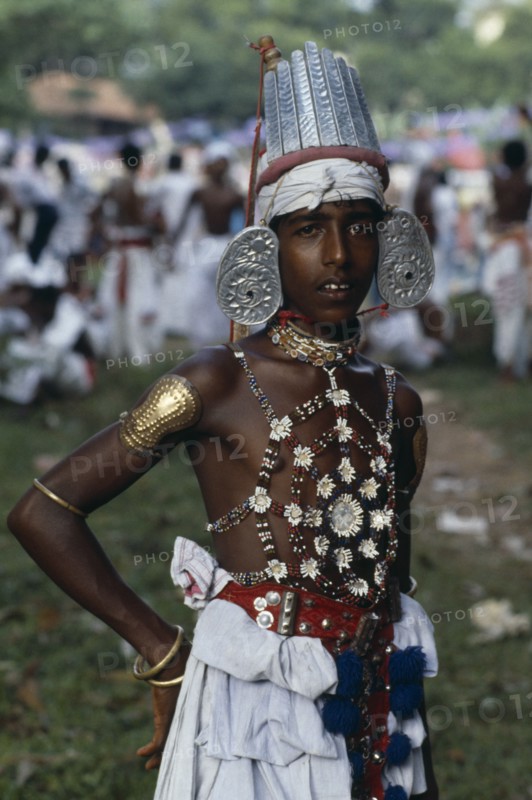 SRI LANKA, Kandy, Portrait of young man dressed for Kandy Esala Perahera.  Procession to honour sacred tooth ehshrined in the Dalada Maligawa Temple of the Tooth.