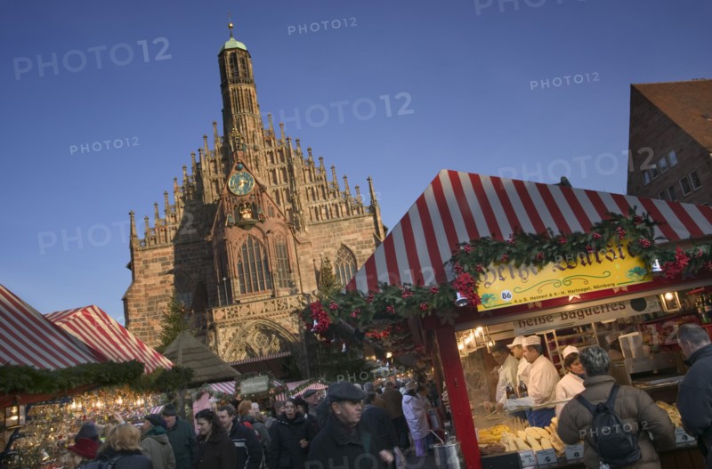 GERMANY, Bavaria, Nuremberg, The Christmas Market in Hauptmarkt with The Frauenkirche behind.