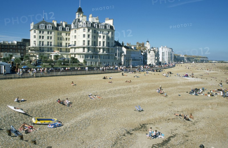 ENGLAND, East Sussex, Eastbourne, Busy shingle beach and beachfront buildings.