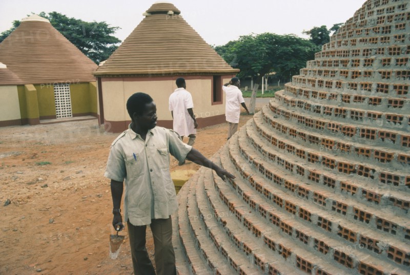 ANGOLA, Tradtional Homes, Builder working on new village housing.