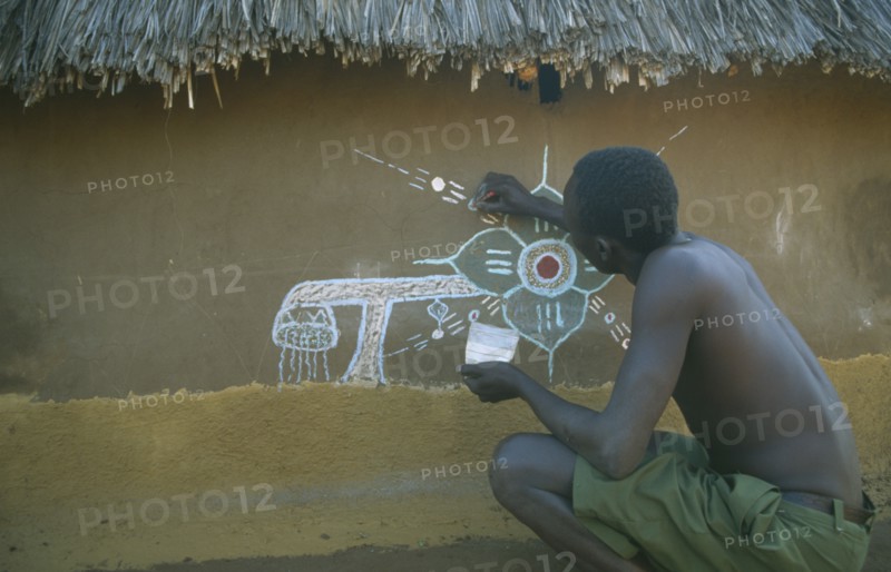 KENYA, Kakuma, Dinka man decorating house in refugee camp.