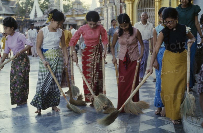 MYANMAR, Yangon, Schwedagon Pagoda.  Women sweeping black and white chequered floor of pagoda.