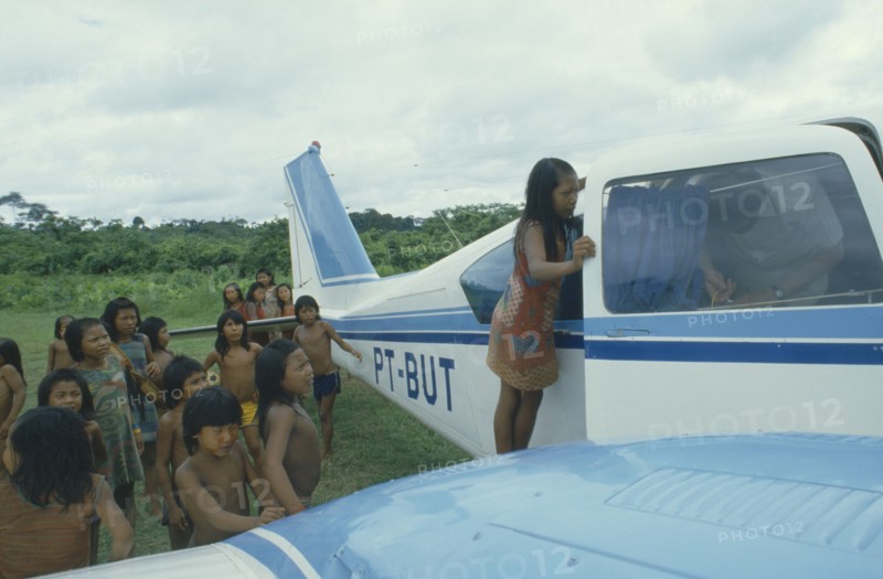 BRAZIL, Amazon, Transport, Xikrin Indian children crowding around small plane.