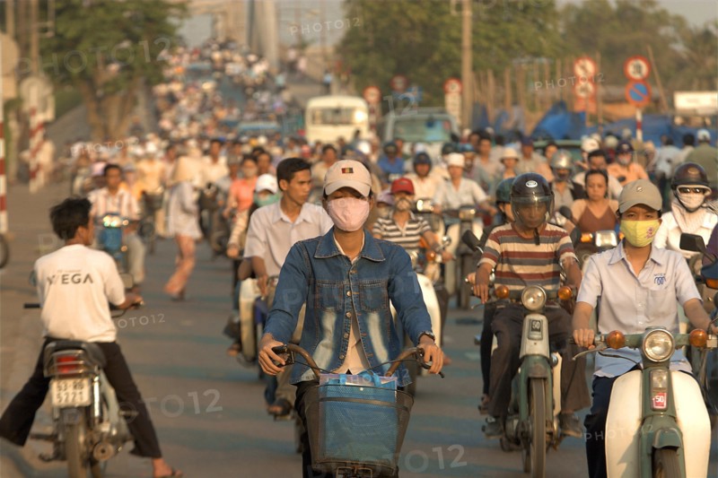 VIETNAM, South, Ho Chi Minh City, Busy street with people riding motorbikes and bicycles