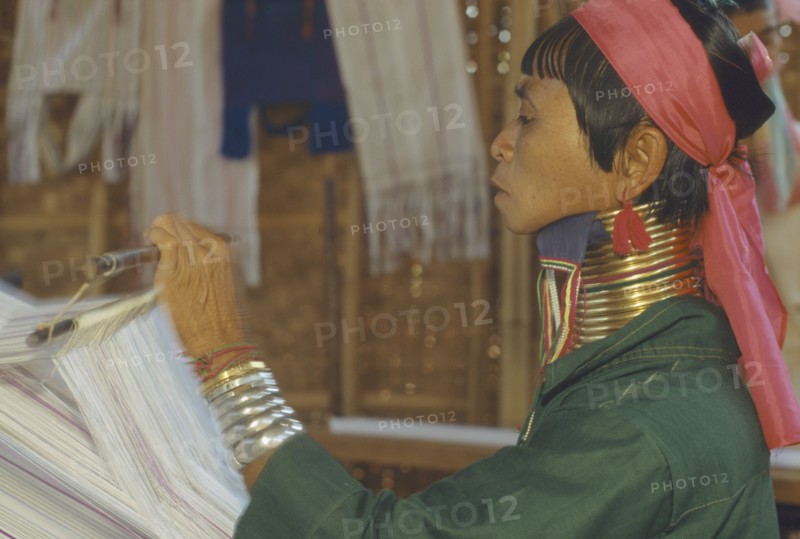 THAILAND, Chiang Rai, "Woman weaving at Karennie village. Paduang, long neck, metal rings."