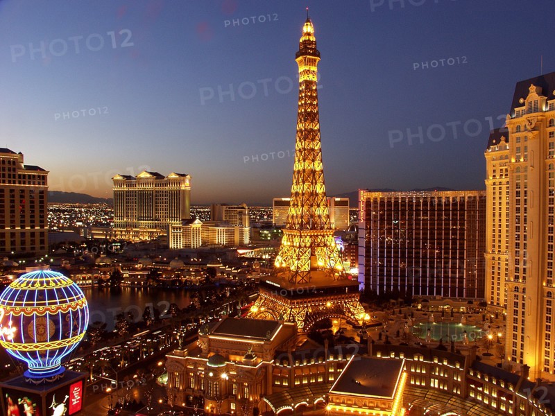 USA, Nevada, Las Vegas, Paris Hotel exterior with the mock Eiffel Tower and Hot air ballon in the foreground lit up at night
