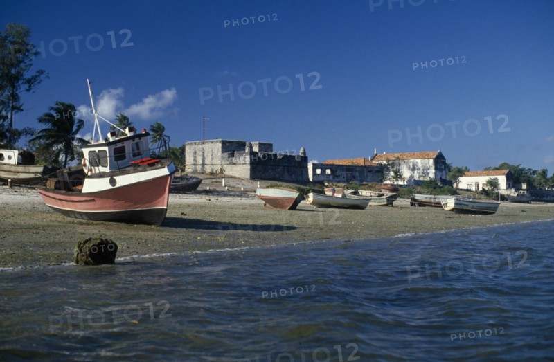 MOZAMBIQUE, Ile de Ibo, "Fishing boats pulled up on shore with crenellated walls of fort behind,"
