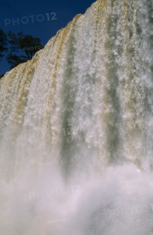 ARGENTINA, Iguazu Falls, Looking up at the water pouring over the edge with water spray.