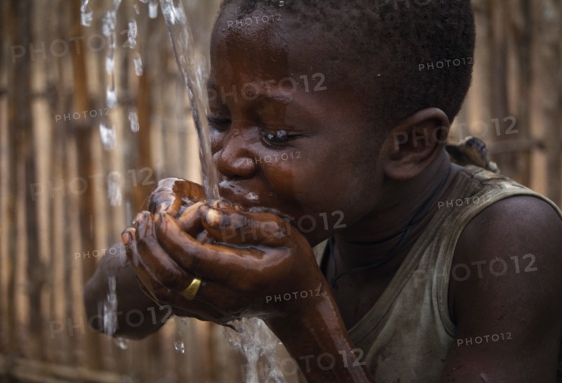 SIERRA LEONE, Water, Child cupping his hands together drinking well water