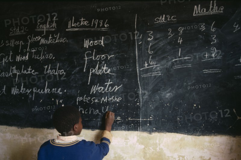 LESOTHO, Education, School, Boy in classroom writing in English on chalk board
