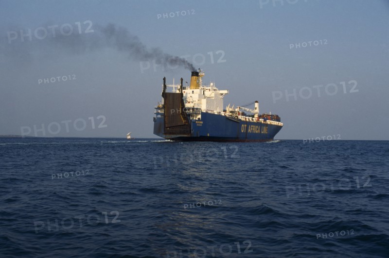 GHANA, Transport, Container ship leaving Tema port emitting stream of thick black smoke from central funnel.