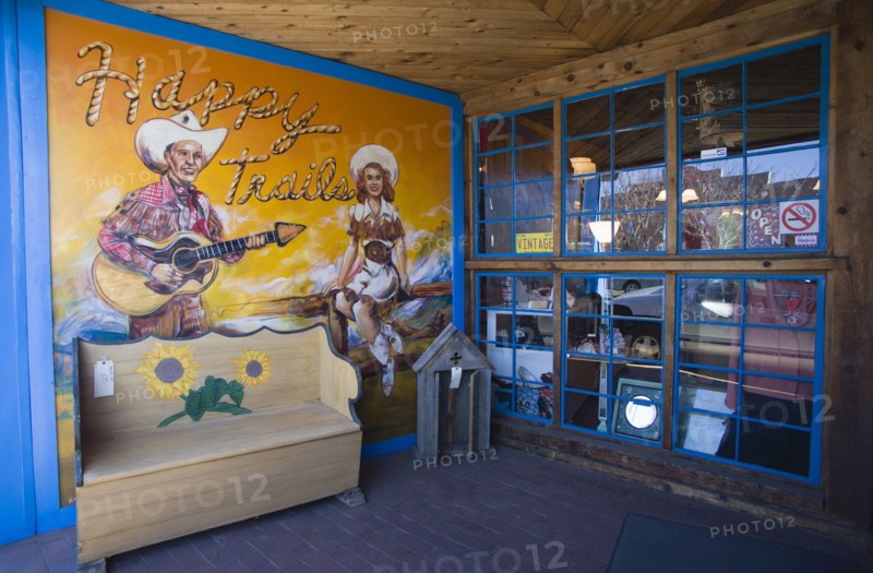 USA, New Mexico, Santa Fe, Happy Trails local arts and crafts shop and its front wall painted with a picture of a cowgirl and a cowboy playing a guitar