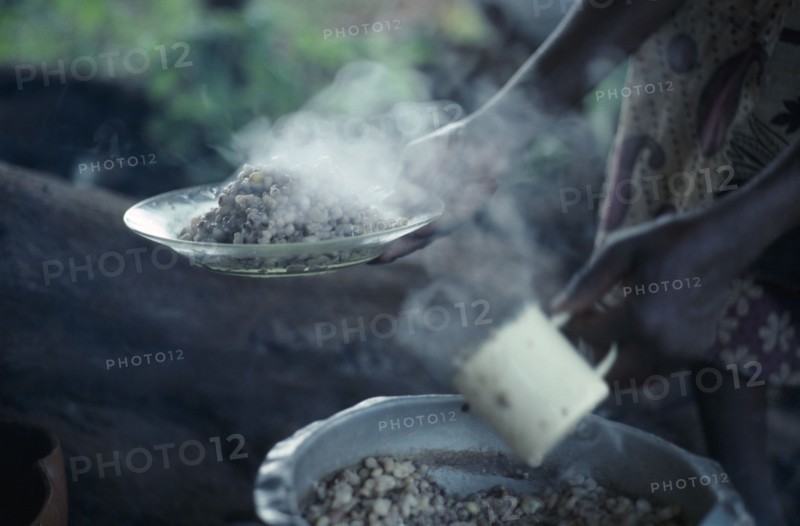 KENYA, Food, "Cropped view of woman holding plate of cooked beans, the staple diet of the Kambas, Bantu people who live in the semi-arid eastern province."