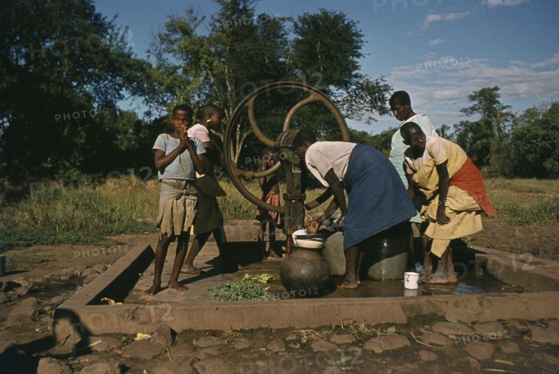 ZAMBIA, Water, Women and children at well.