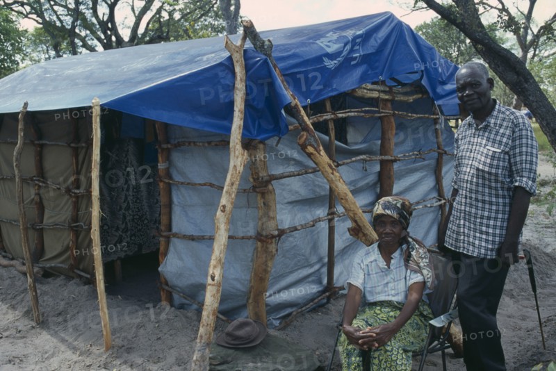 ZAMBIA, Mayukwayukwa Camp, Elderly couple beside shelter in camp for Angolan refugees.