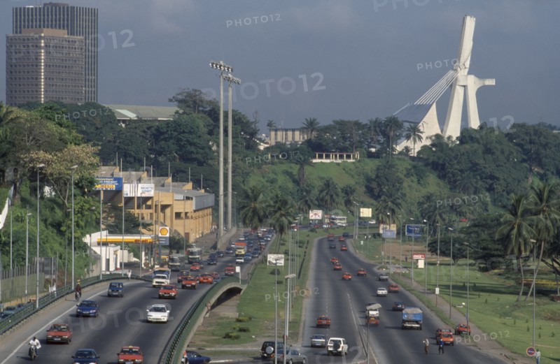IVORY COAST, Abidjan, Cityscape with multi-lane traffic and modern exterior of St Paul’s Cathedral