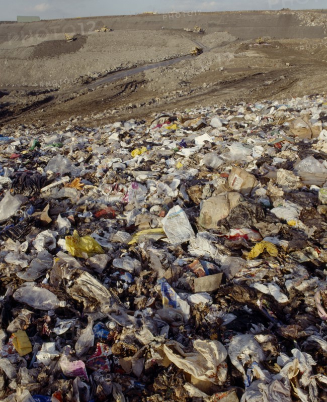 ENVIRONMENT, Rubbish, View across waste on a Infill site towards trucks used to move the rubbish