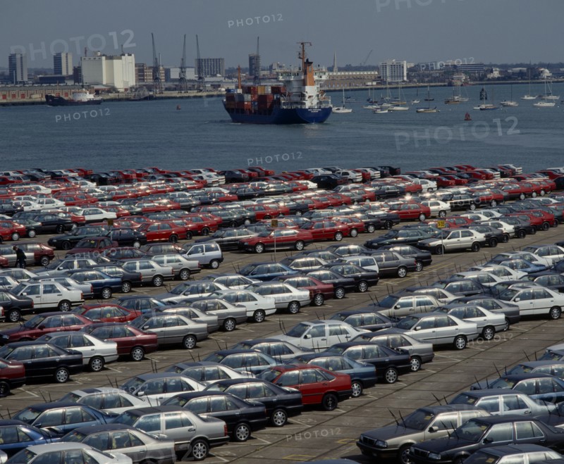 INDUSTRY, Cars, Southampton Docks. Rows of imported cars with container ships and boats on the water