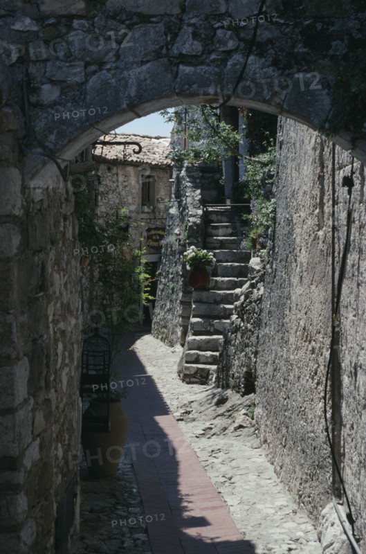 FRANCE, Provence Cote D Azur, Alpes Maritime, Eze. Walled alley way with stone steps leading up to building