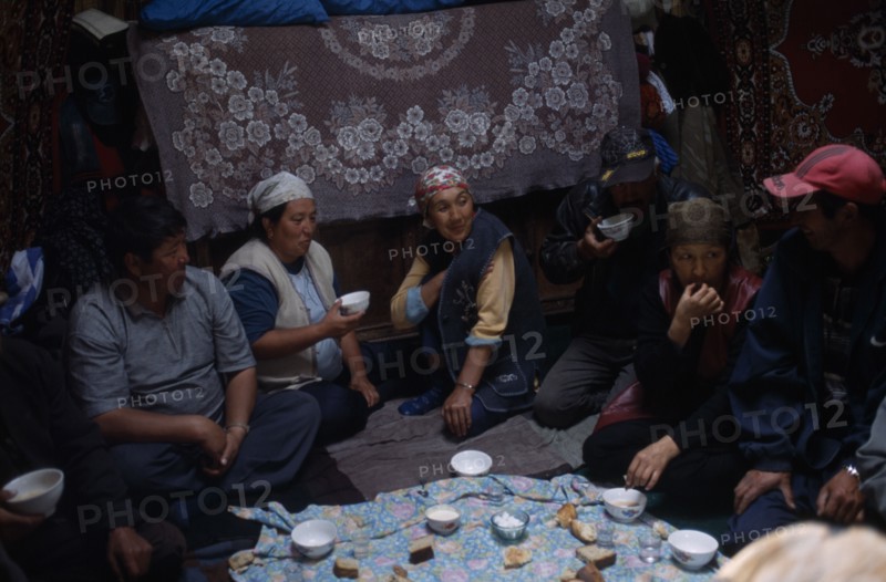 KIRGHIZSTAN, Workers, "Shepherds inside a yurt, eating and drinking, large rugs hanging on the walls"