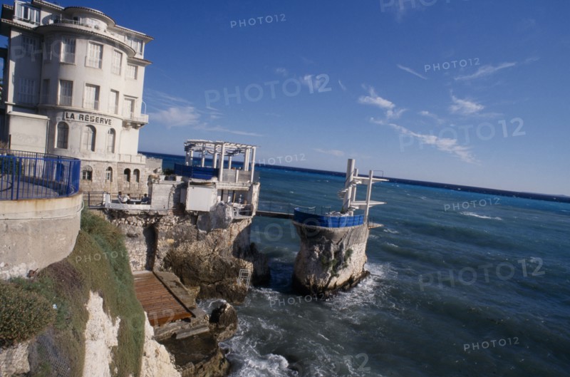 FRANCE, Provence Cote d’Azur, Alpes Maritimes, Nice. Cap de Nice. Diving port built on rocks along coastline next to La Reserve building