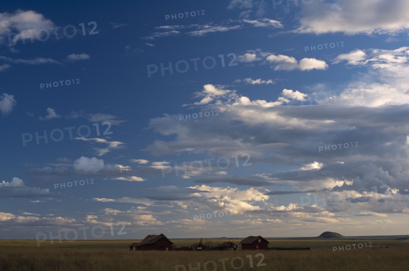 MADAGASCAR, Landscape, Small settlement in the Horombe Plateau with an expanse of sky and cloud formations above