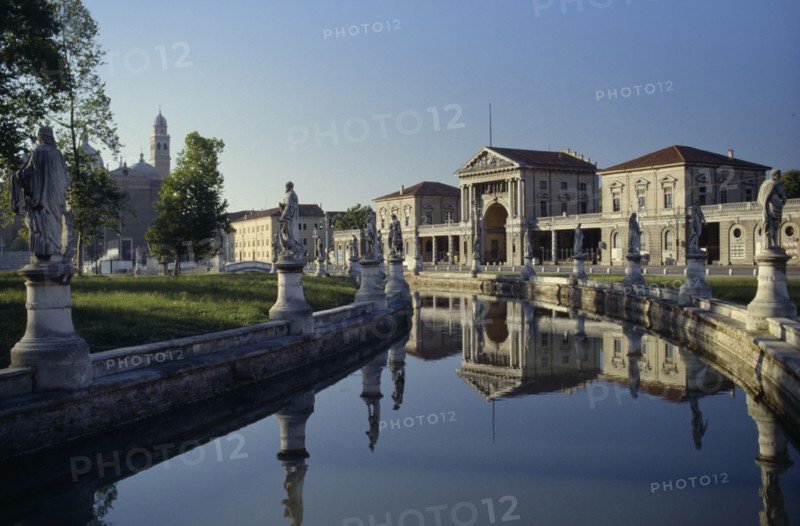 ITALY, Veneto, Padua, Prato della Valle.  Canal surrounding oval green island along which stand statues of famous cultural figures.