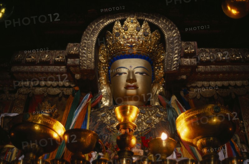 CHINA, Tibet, Gyantse, "Butter lamps and a statue of Sakyamuni, the present Buddha, in Pelkor Chode Monastery."