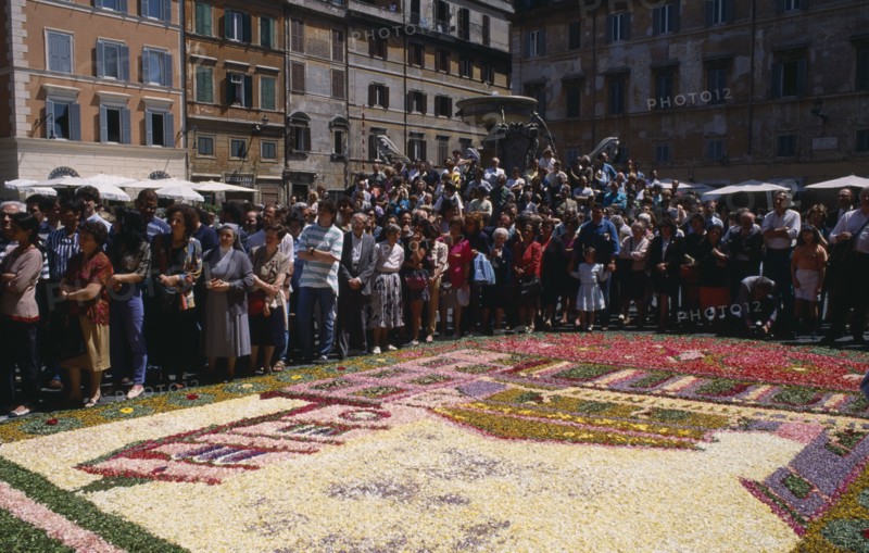 ITALY, Lazio, Rome, Santa Maria in Trastevere with crowds gathered for display of flower petal mosaic in Piazza di Santa Maria during Infiorata di Gerano.