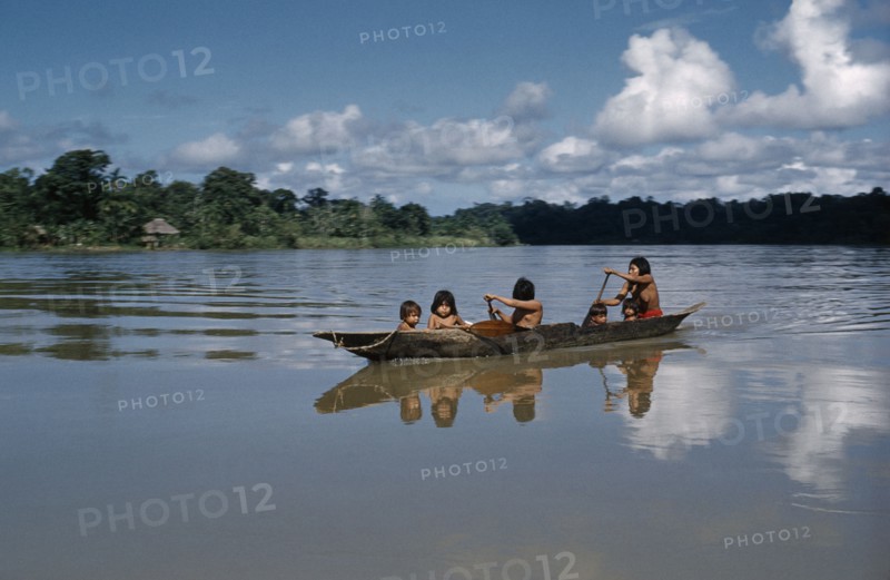 COLOMBIA, Choco Region, Noanama Tribe, Mother paddles her family across the lower rio San Juan