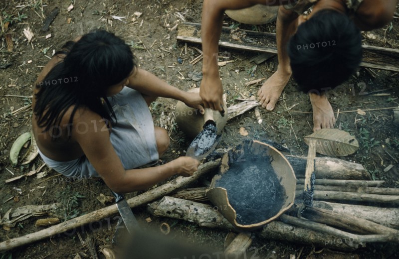 COLOMBIA, Choco Region, Noanama Tribe, Woman pouring “breo” / melted beeswax into a fired “cantaro” / clay water pot which will now be watertight