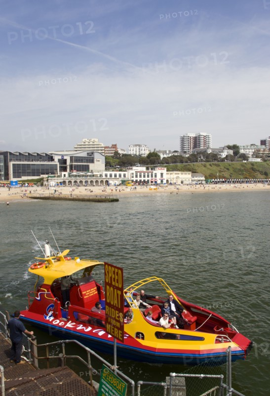 ENGLAND, Dorset, Bournemouth, Speed Boat ride from the Pier with The East Beach and the Imax Complex on the left beside seafront restaurants and bars. Tourists enjoy the sandy beach.