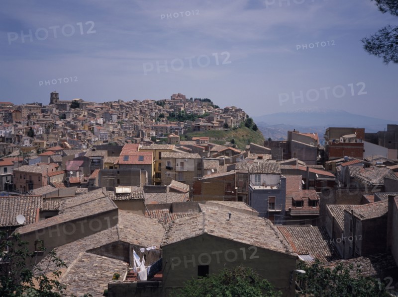 ITALY, Sicily, Enna Province, View East over the rooftops of the hilltop city towards Mount Etna