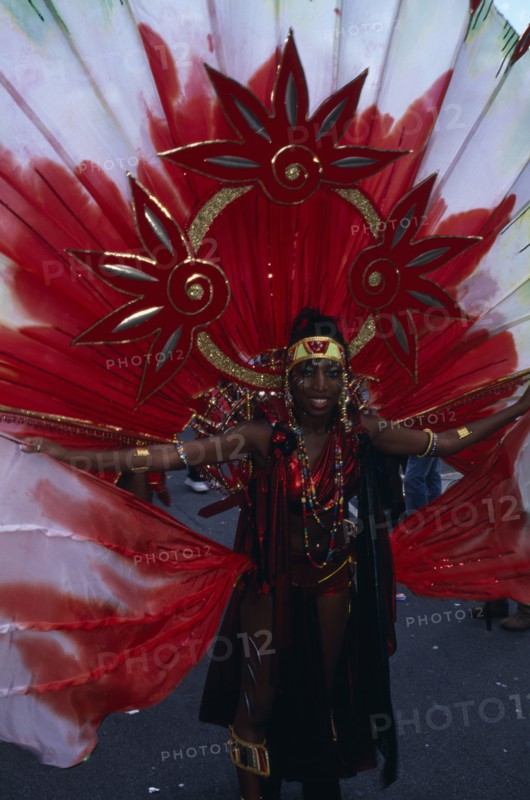 ENGLAND, London, Notting Hill carnival woman in extravagant red costume.