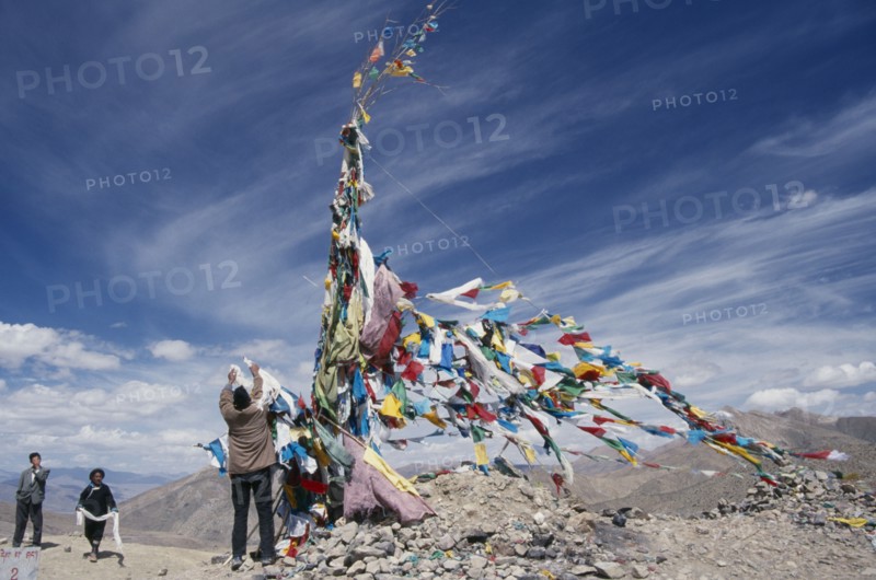 CHINA, Tibet, Tscho La, "Tibetans adding katas, Buddhist ceremonial scarves, to the prayer flags at the top of Tscho La."