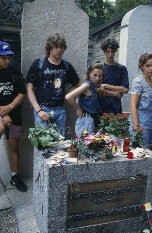 FRANCE, Ile de France, Paris, Pere Lachaise Cemetery. Visitors surrounding Jim Morrison’s Grave
