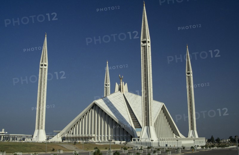 PAKISTAN, Islamabad, "Shah Faisal mosque.  Designed by Vedat Dalokay, construction completed 1986.  White exterior with pyramidal roof and four minarets."